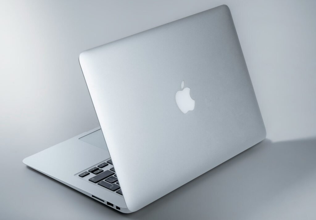 silver macbook on white table