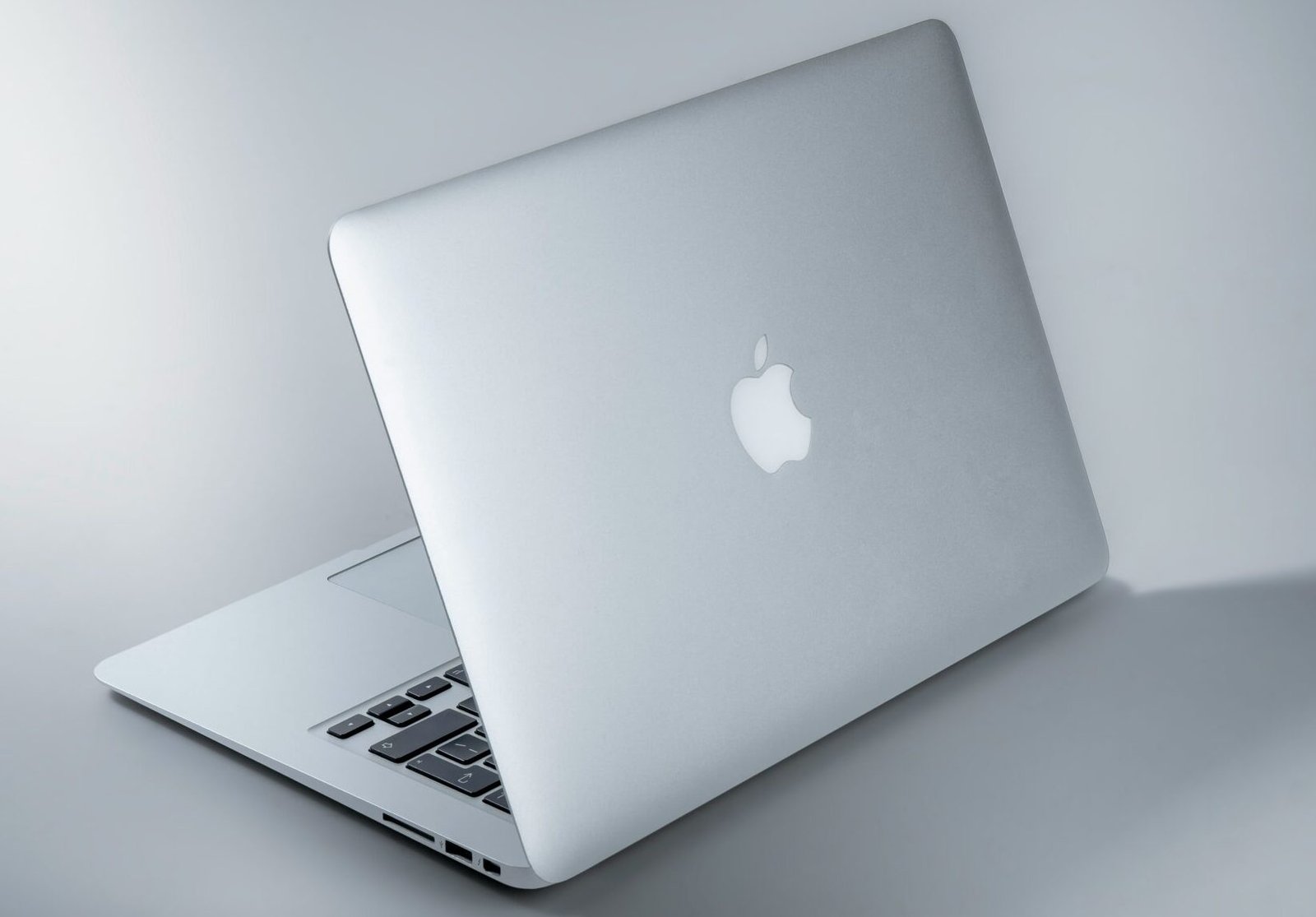 silver macbook on white table